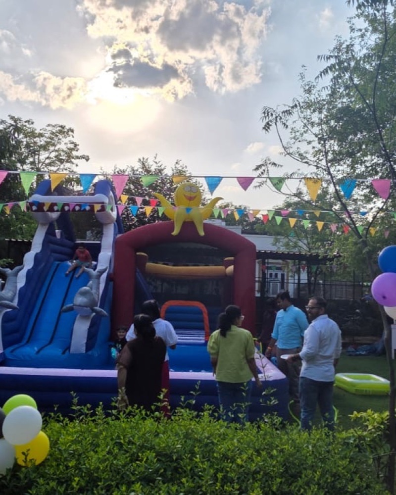 A bouncy castle under bunting on the lawns at a birthday party